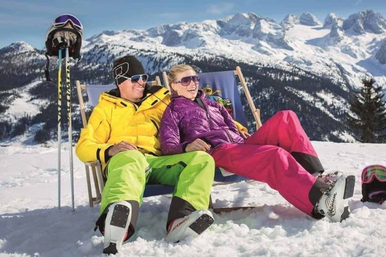 Paar entspannt im Liegestuhl im Schnee, Berge Salzburg, Skiferien Hotel Kirchenwirt Puch